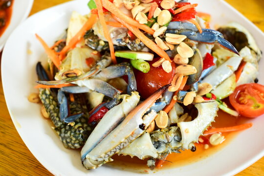 Thai spicy raw blue crab salad serve on a white plate, traditional Thai seafood cuisine