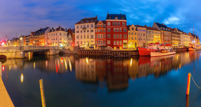 Nyhavn harbor panorama with colorful waterfront buildings at dawn in Copenhagen Denmark