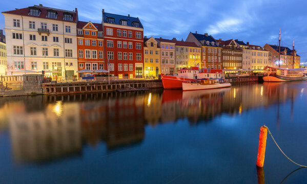 Nyhavn harbor panorama with colorful waterfront buildings at dawn in Copenhagen Denmark