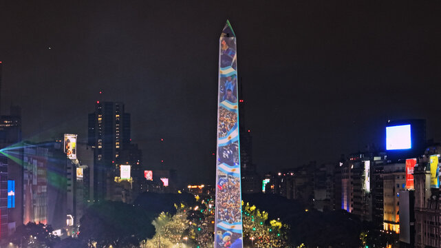 Buenos Aires, Argentina - 19 July 2026: Aerial view of the Obelisco de Buenos Aires illuminated with projections during a night celebration with crowds and city lights.