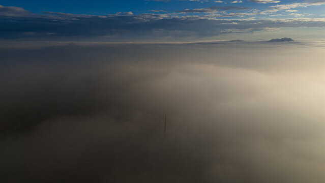 Aerial view of the Akyokus tower tip emerging from a thick blanket of clouds at sunrise in Meram, Konya, Turkiye.