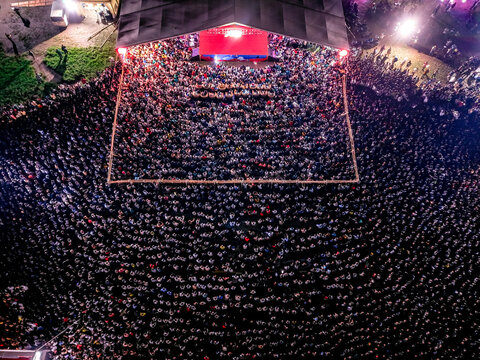Dhaka, Bangladesh - 20 July 2026: Aerial view of a massive crowd gathered at an outdoor concert at night, with a brightly lit stage and dense audience in Dhaka, Bangladesh.