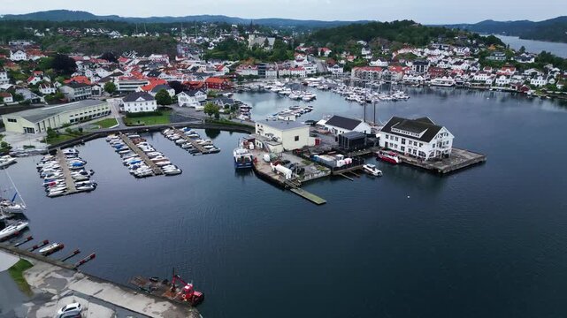 Aerial view of the coastal town of Grimstad with its harbor, marina, and white buildings along the waterfront in Grimstad, Agder, Norway.