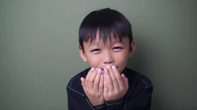 Young Muslim boy raising both hands while making dua in prayer. Islamic worship, faith, spirituality, Ramadan, Eid, hope, and religious devotion concept. Static portrait shot.