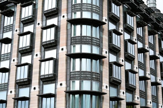 View of the modern architectural facade featuring repetitive bay windows and stone cladding in London, England, United Kingdom.