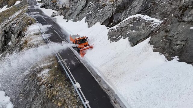 Aerial view of a snowblower clearing deep snow from the Transfagarasan mountain road in Curtea de Arges, Judetul Arges, Romania.