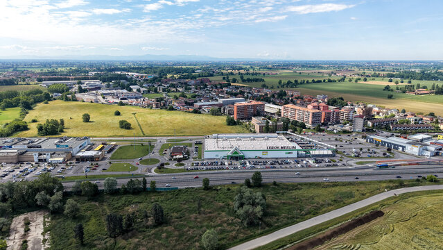 Pantigliate, Italy - 23 May 2026: Aerial view of the Leroy Merlin retail complex surrounded by parking areas, a highway, and residential buildings in the Lombardia region.