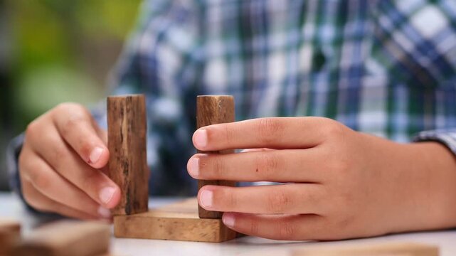 kid playing with wooden bricks. Children constructing house from colored elements. Bright toy building - real estate theme.