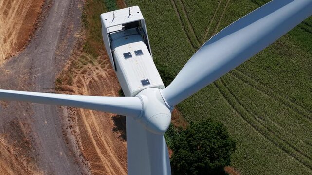 Aerial view of the white turbine blades and nacelle of Keadby Wind Farm set against green fields and rural landscape in Keadby, England, United Kingdom.