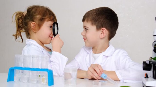 Laboratory examination of a child with test tubes, reagents and a microscope. Selective focus.