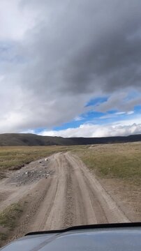 Vertical video of driving along the valley of Lake Akkul and the Akkol River in Altai on a sandy road.
