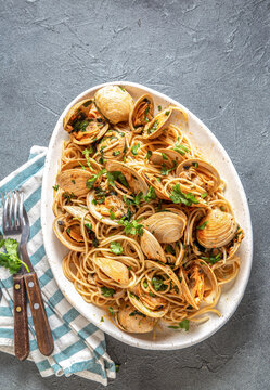 Seafood Italian Pasta. Spaghetti with vongole. Clams spaghetti on white plate with white wine