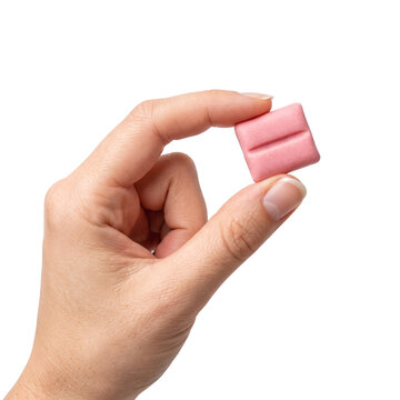 Hand holding pink chewing gum square isolated on black background