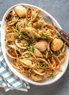 Seafood Italian Pasta. Spaghetti with vongole. Clams spaghetti on white plate with white wine