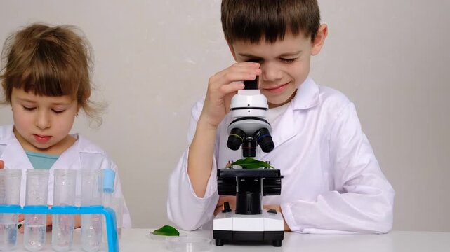 Laboratory examination of a child with test tubes, reagents and a microscope. Selective focus.
