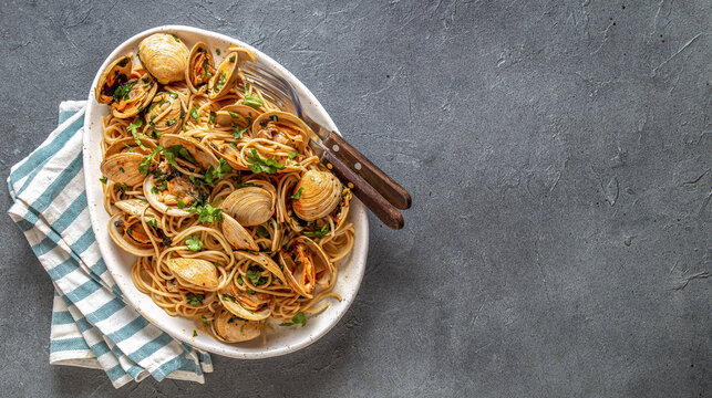 Seafood Italian Pasta. Spaghetti with vongole. Clams spaghetti on white plate with white wine
