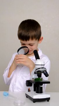 Laboratory examination of a child with test tubes, reagents and a microscope. Selective focus.