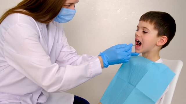 A child at the dentist gets his teeth treated. Selective focus.