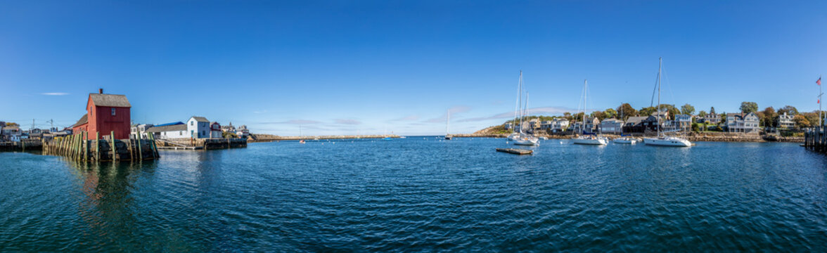 scenic view to rockport old Marina with village with traditional wooden houses in background