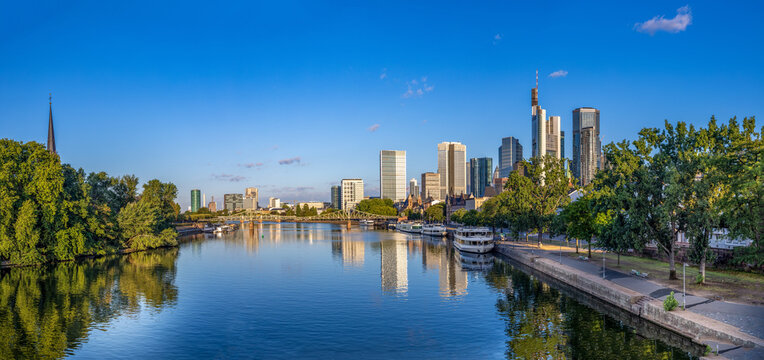 scenic skyline of Frankfurt am Main in early morning light and reflection in river Main