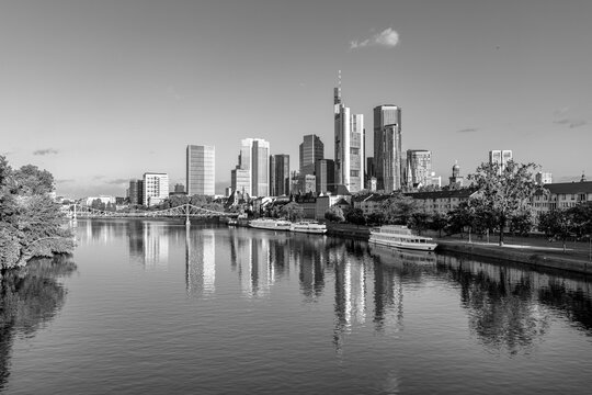 scenic skyline of Frankfurt am Main in early morning light and reflection in river Main