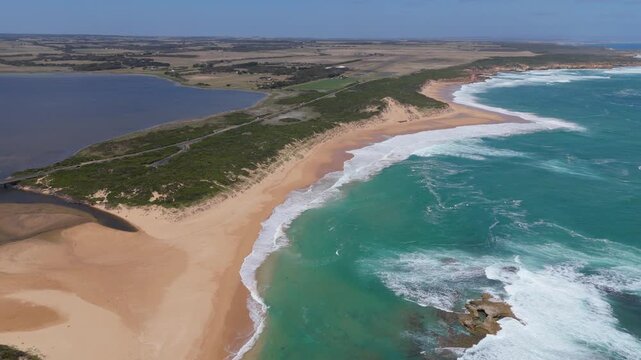 Aerial Drone Shot Tracking Along Sandy Coastline and Ocean Waves at Peterborough Beach in Victoria, Australia.