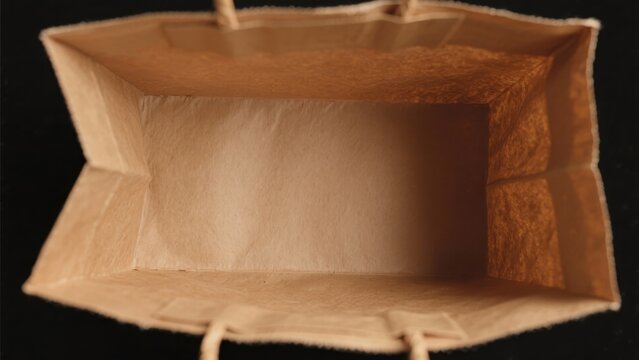 A close-up of a paper shopping bag viewed from directly above showing its interior empty space