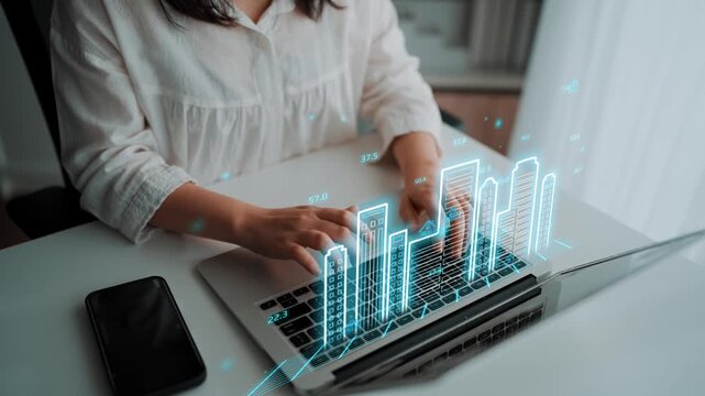 A professional analyzes data on a laptop with digital graphs overlay, illustrating growth and trends in a modern office setting. Ideal for business and technology themes. Entropy.