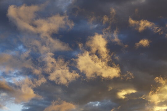 Golden clouds glow in a stormy sky.