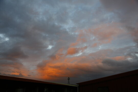 Orange clouds glow above building roofs.