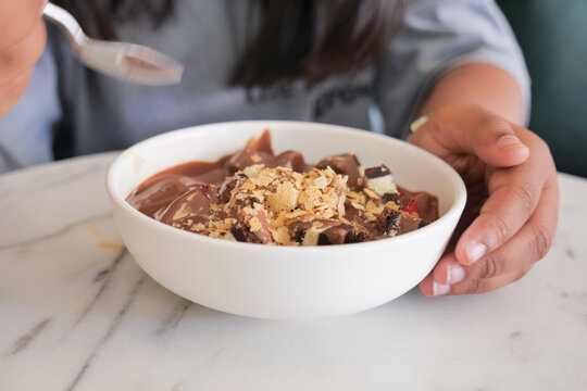 Bowl of dessert with chocolate, nuts, and toppings