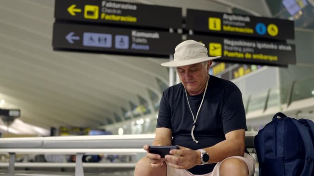Tourist playing mobile game at airport terminal
