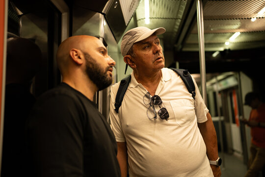 Two men riding subway train during urban commute