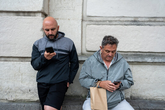 Men using smartphones connecting with technology outdoors