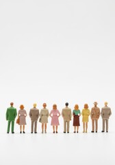 Fototapeta premium Diverse Group of Miniature Human Figures Standing Together on White Background for Business and Social Concepts