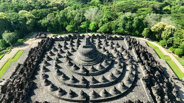 Cinematic low flyby over Borobudur temple, majestic ancient pyramid structure in Java, aerial drone shot.