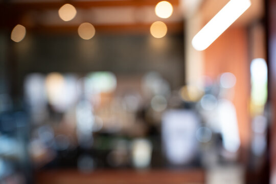 Abstract soft background of a modern coffee shop counter featuring rows of espresso bean grinders and a working barista, creating a warm inviting atmosphere for typography and graphic design.