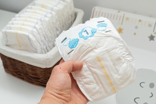 Parent Taking a Clean Disposable Diaper From a Nursery Basket