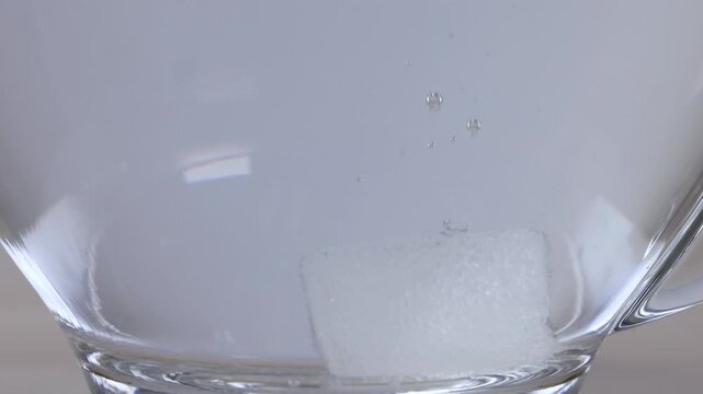 Sugar Cube Dissolving in a Glass Mug of Hot Water