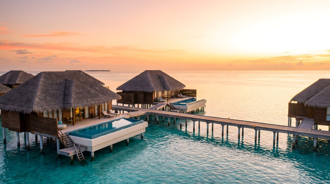 Luxury overwater bungalows with infinity pools at tropical sunset