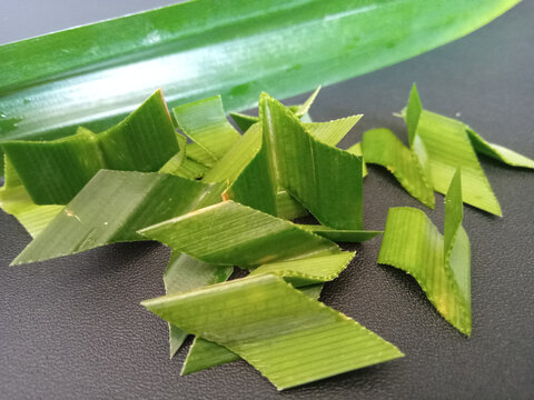 Fresh sliced green pandan leaves on black background