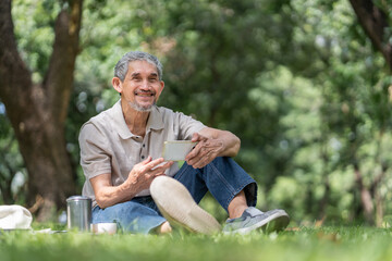 Obraz premium portrait elderly pensioner man spend leisure time relaxing in urban park,sitting and surfing internet on smartphone
