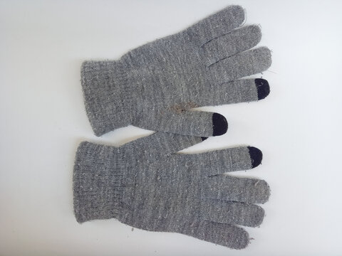 Pair of gray knitted winter gloves featuring black touchscreen fingertips.