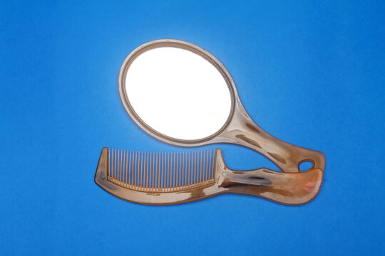 comb and mirror isolated on blue background