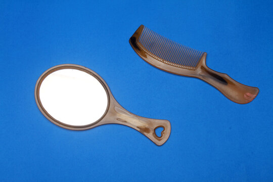 mirror and comb isolated on blue background