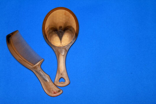 comb and mirror isolated on blue background