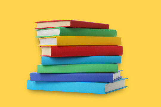 Books arranged in a stack on a colorful backdrop ready for study