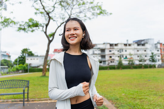 Asian sporty woman running in public park