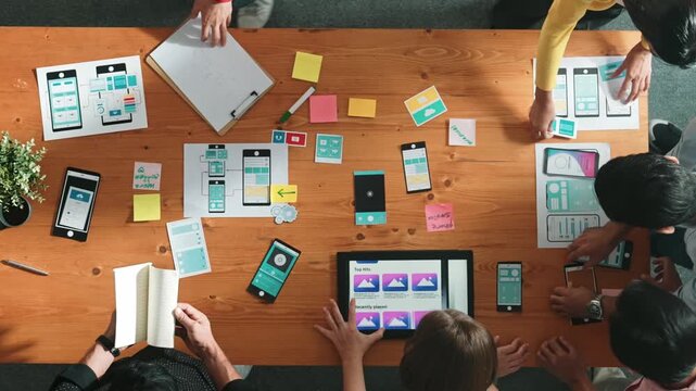 Top view of smart software developer planning software development. Skilled programmer team brainstorming and designing Ux UI design for mobile phone interface or digital creative design. Convocation.