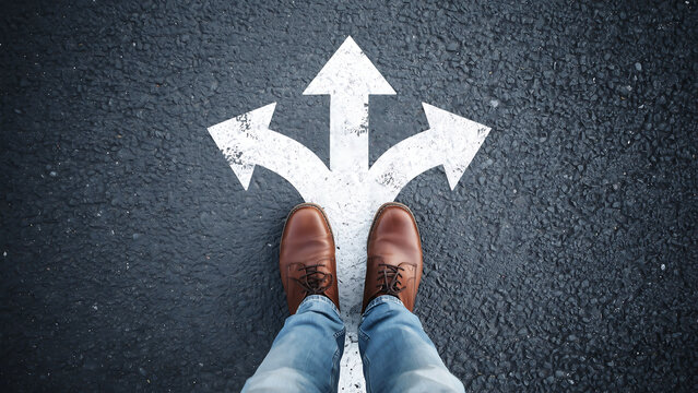 Person standing at a three way decision point marked on asphalt road with direction decision junction navigation movement opportunity